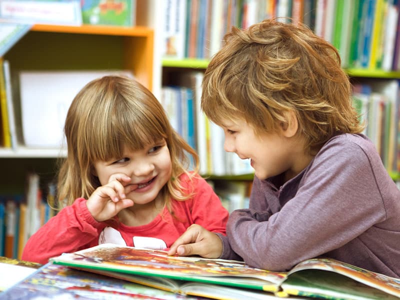 two young children reading in a library
